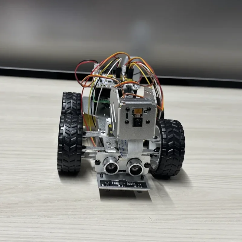 The rover head on: the camera above, two range sensors below it, the line-sensor bar at the bottom, a tyre on either side.