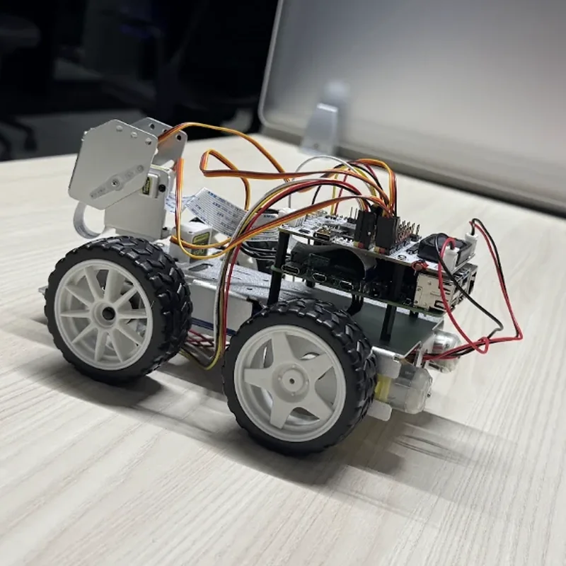 The rover from its left rear quarter: the back of the board stack and its power leads, the camera bracket beyond.