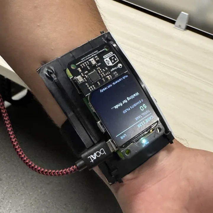 The wrist unit from above. Its screen reads: Case 1138, live, total take 0 dollars, 0 exhibits filed, waiting for finds.